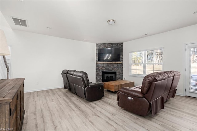 living room with a fireplace and light hardwood / wood-style flooring