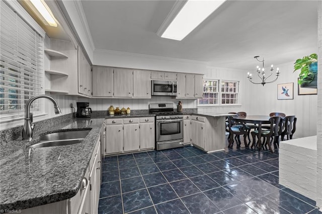 kitchen with appliances with stainless steel finishes, decorative light fixtures, sink, ornamental molding, and kitchen peninsula