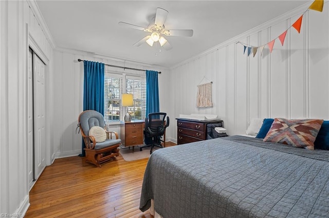 bedroom featuring ceiling fan, ornamental molding, a closet, and light wood-type flooring