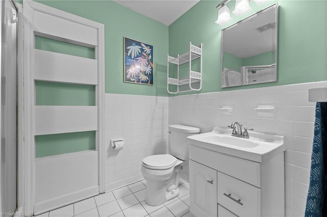 bathroom featuring tile walls, vanity, tile patterned floors, and toilet