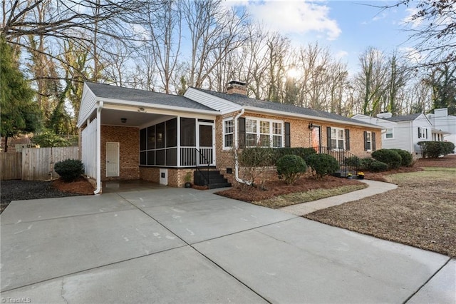 ranch-style house with a carport and a sunroom