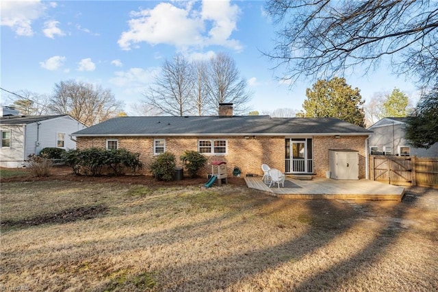 back of house featuring a wooden deck and a lawn