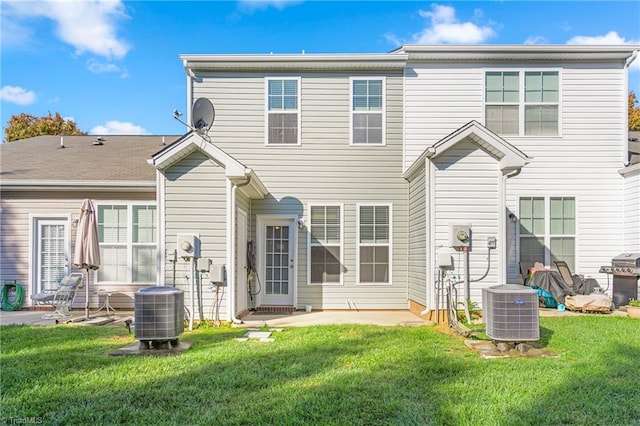 back of house with a lawn, central air condition unit, and a patio