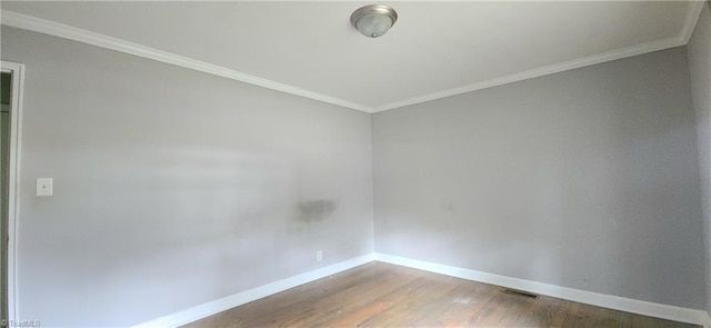 empty room with hardwood / wood-style flooring and ornamental molding