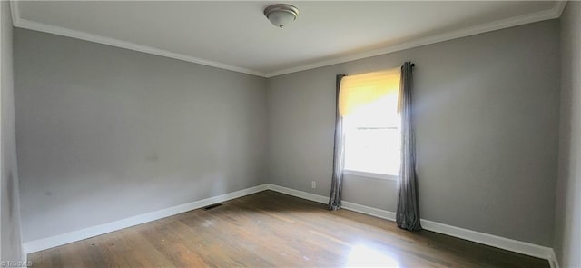 spare room with ornamental molding and hardwood / wood-style floors