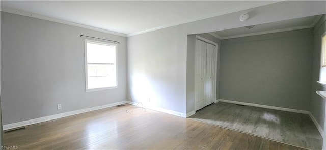 spare room with crown molding and hardwood / wood-style floors