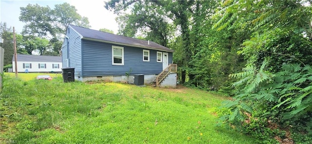 back of house with cooling unit and a yard