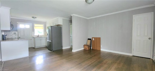 interior space featuring stainless steel appliances, ornamental molding, dark hardwood / wood-style floors, and white cabinets