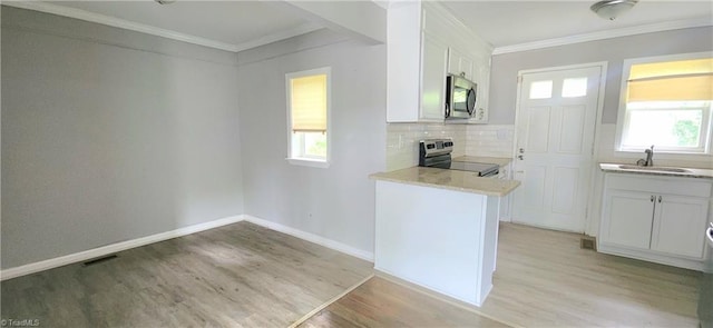 kitchen with stainless steel appliances, crown molding, sink, and white cabinets