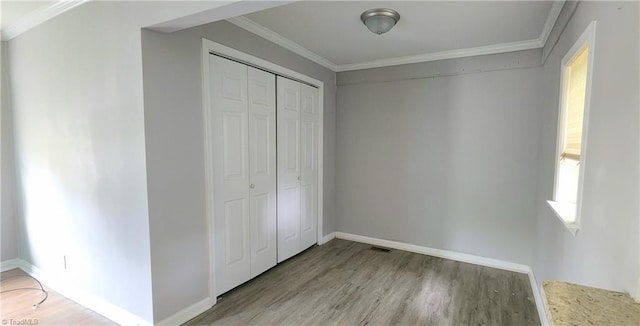 unfurnished bedroom featuring ornamental molding, light hardwood / wood-style floors, and a closet