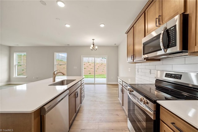 5757 Siler St, Trinity, NC 27370 - kitchen with appliances with stainless steel finishes, brown cabinetry, a sink, and a wealth of natural light
