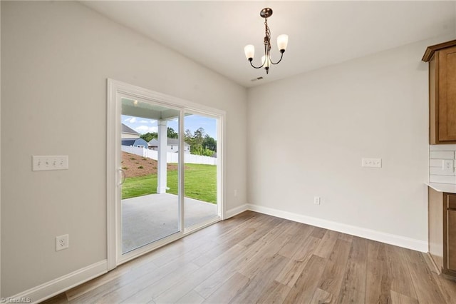 5757 Siler St, Trinity, NC 27370 - unfurnished dining area with baseboards, light wood finished floors, and a notable chandelier