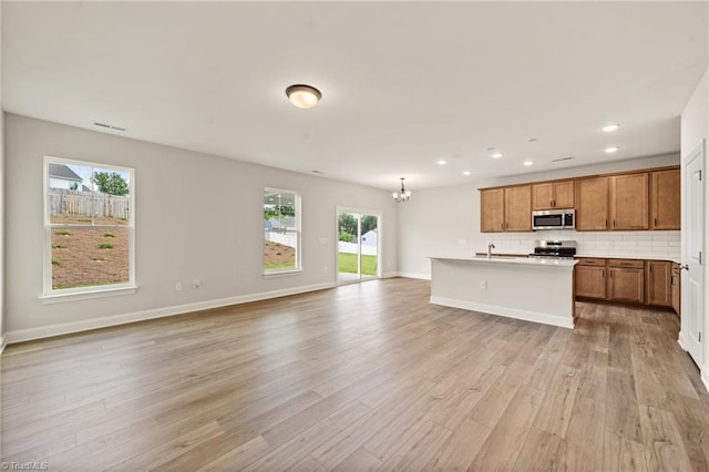 5757 Siler St, Trinity, NC 27370 - kitchen featuring brown cabinets, a sink, open floor plan, an inviting chandelier, and stainless steel appliances