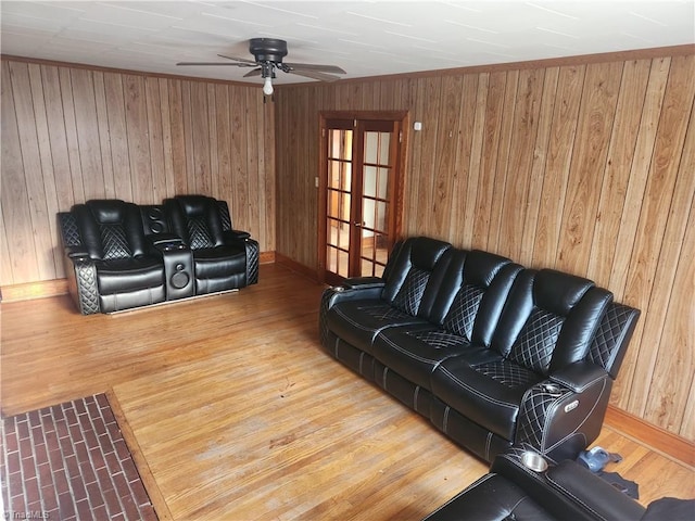 living room with wood-type flooring, french doors, and wooden walls