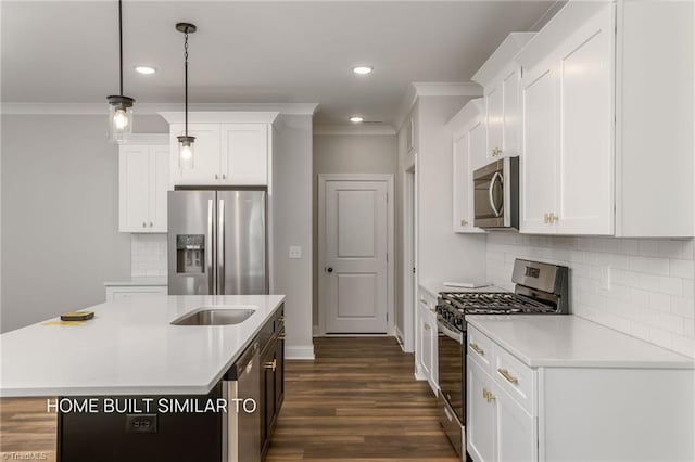 6963 Orchard Path Dr, Clemmons, NC 27012 - kitchen featuring appliances with stainless steel finishes, ornamental molding, light countertops, a kitchen island with sink, and dark wood finished floors