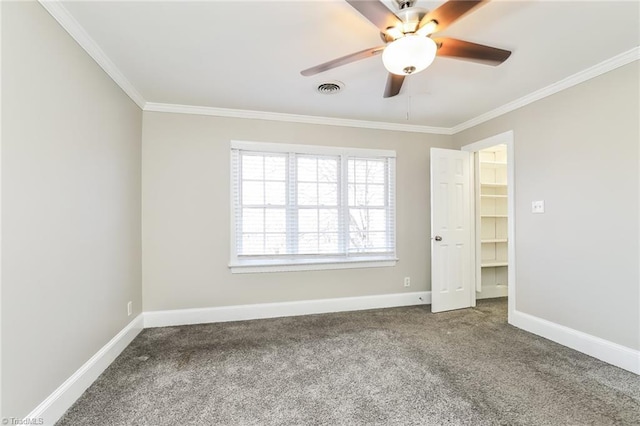 unfurnished bedroom with visible vents, baseboards, carpet flooring, and crown molding