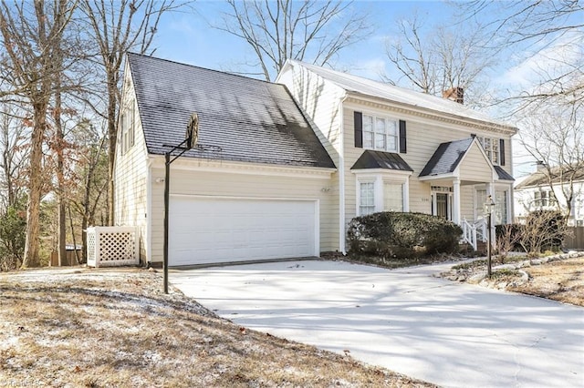 view of front facade with a garage, driveway, and a chimney