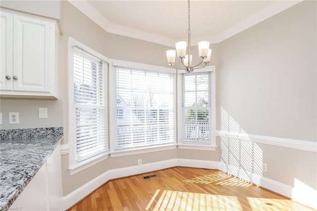 dining space featuring a notable chandelier, baseboards, light wood-style floors, and ornamental molding