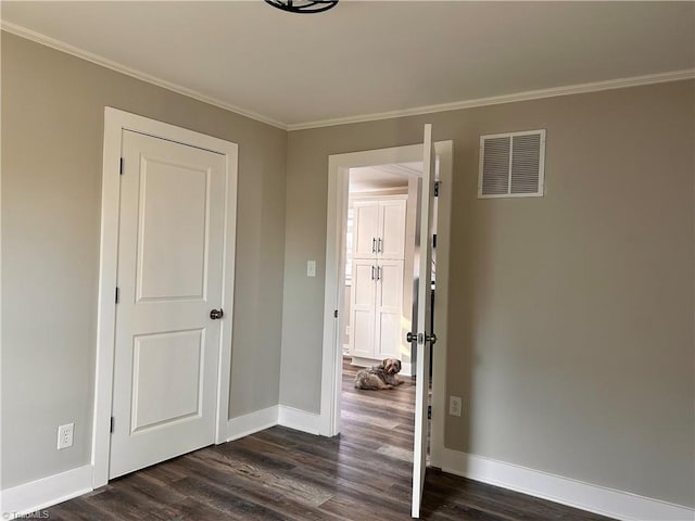 unfurnished bedroom featuring visible vents, crown molding, baseboards, and dark wood-style flooring