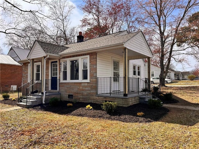 view of front of home featuring roof with shingles, a porch, a chimney, stone siding, and crawl space