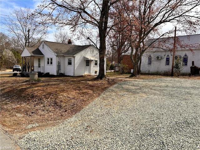 view of side of home with gravel driveway