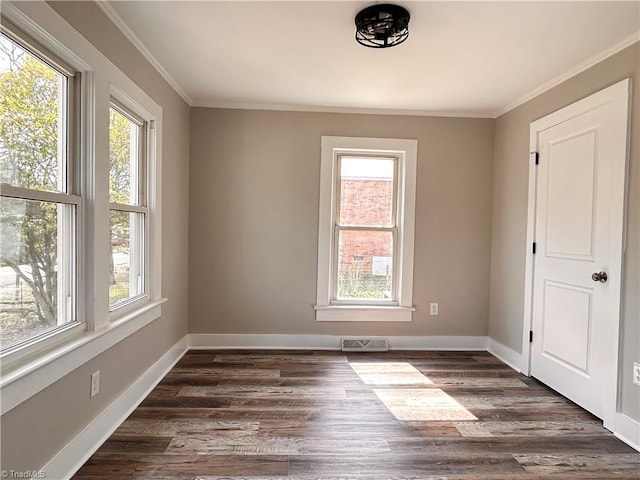 spare room with visible vents, crown molding, dark wood-type flooring, and baseboards