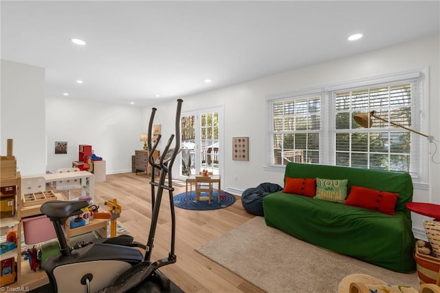 workout room with baseboards, light wood finished floors, and recessed lighting