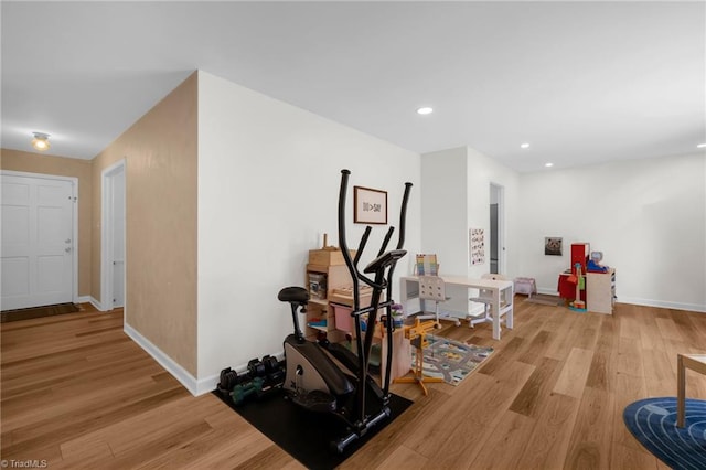 workout area featuring recessed lighting, baseboards, and light wood-type flooring