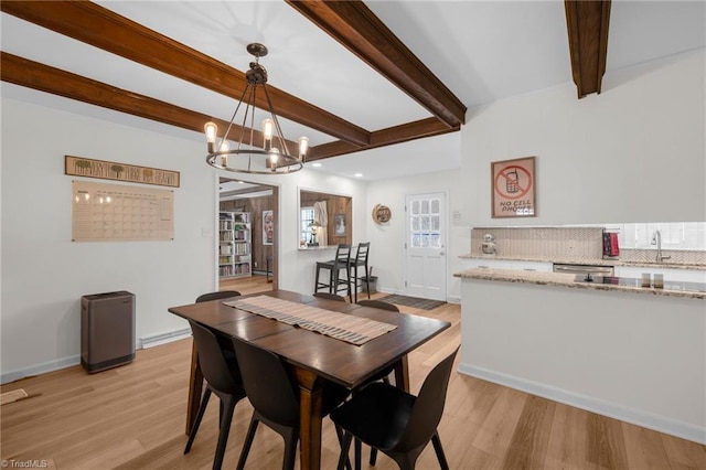 dining space featuring baseboards, beam ceiling, light wood-style flooring, and a notable chandelier