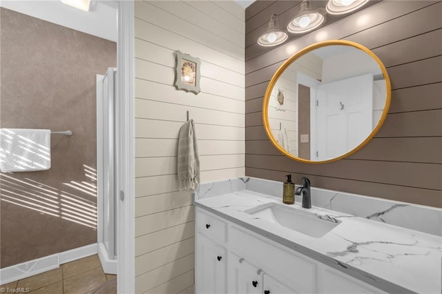 bathroom featuring wooden walls, tile patterned flooring, and vanity