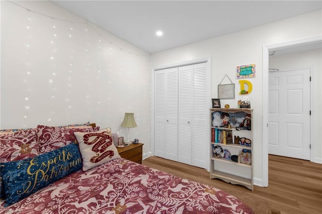 bedroom with a closet, recessed lighting, and wood finished floors