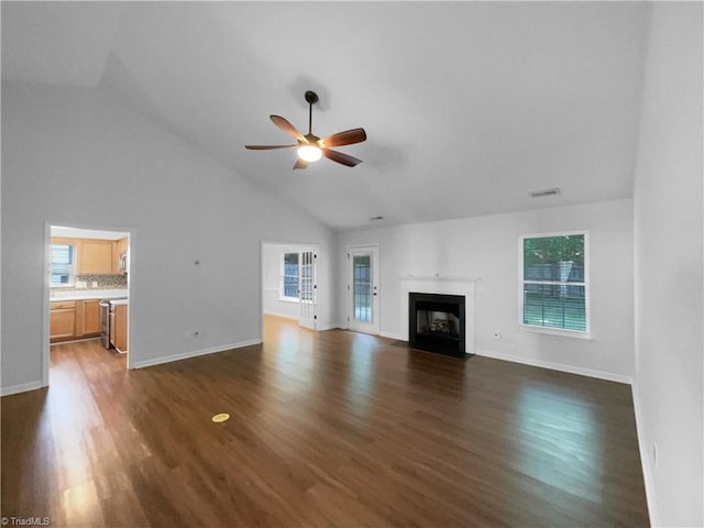 615 Walnut Crossing Dr, Whitsett, NC 27377 - unfurnished living room with a ceiling fan, dark wood finished floors, a fireplace with flush hearth, high vaulted ceiling, and baseboards