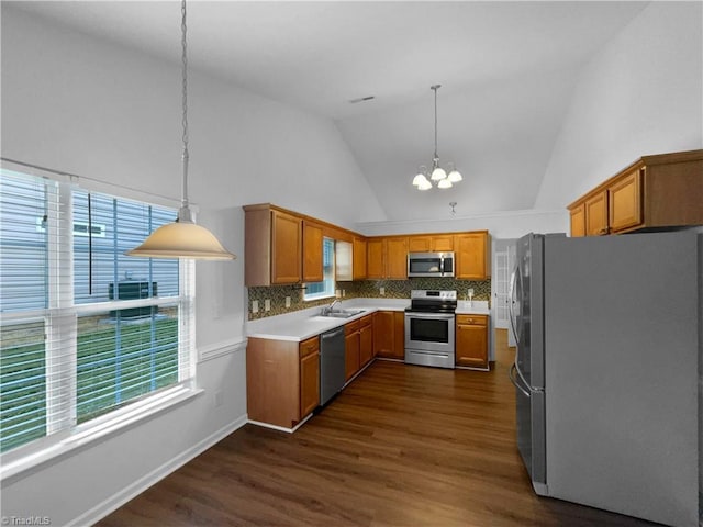 615 Walnut Crossing Dr, Whitsett, NC 27377 - kitchen featuring appliances with stainless steel finishes, a chandelier, high vaulted ceiling, dark wood-style floors, and brown cabinetry
