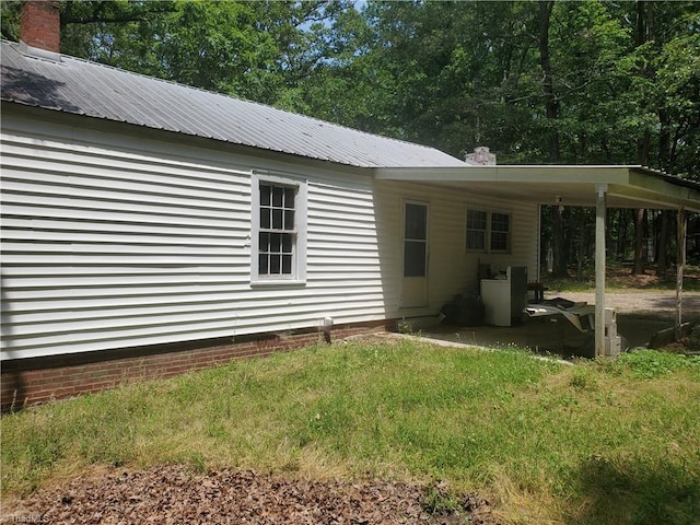 291 Virgil Hill Rd, Asheboro, NC 27205 - view of side of home with metal roof, a carport, and a chimney