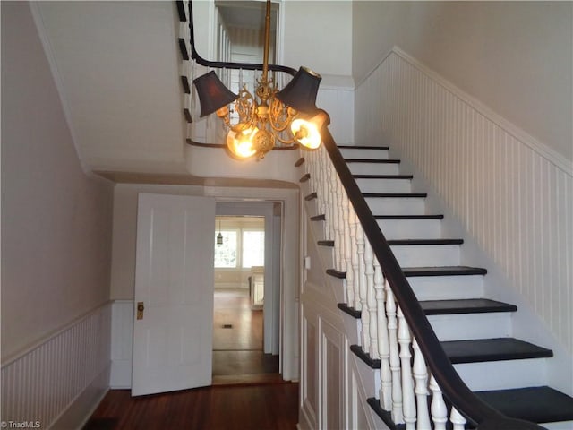 stairs featuring a chandelier and dark hardwood / wood-style floors