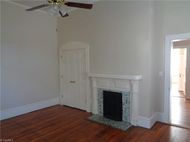 unfurnished living room featuring ceiling fan and dark wood-type flooring