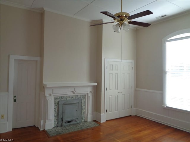 unfurnished living room featuring ceiling fan, dark wood-type flooring, and crown molding