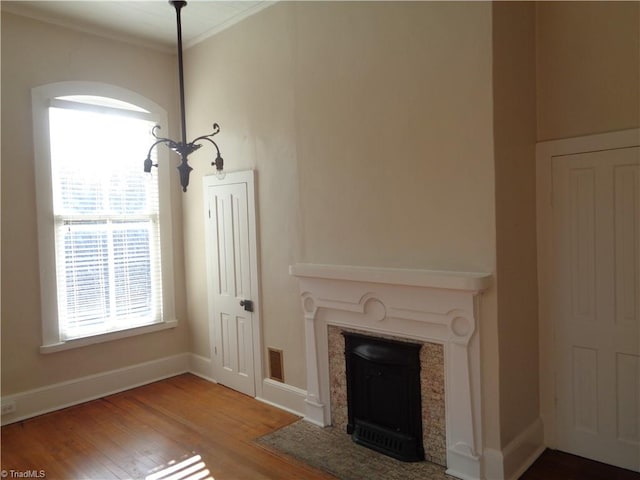 unfurnished living room with ornamental molding and wood-type flooring