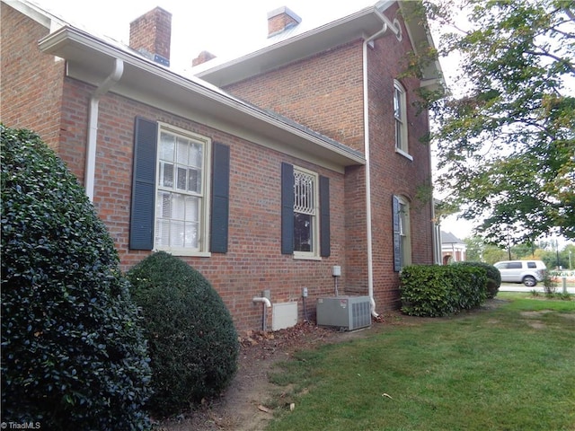 view of property exterior featuring a yard and central AC