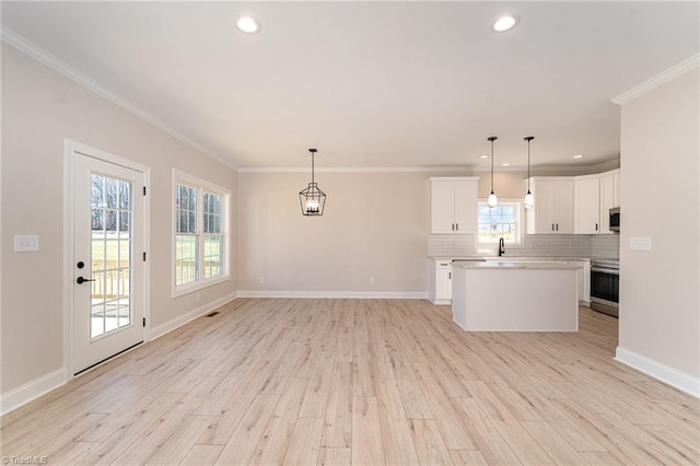 kitchen with light wood-style flooring, stainless steel electric stove, decorative backsplash, and crown molding