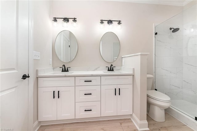 full bathroom featuring a stall shower, a sink, toilet, and wood finished floors