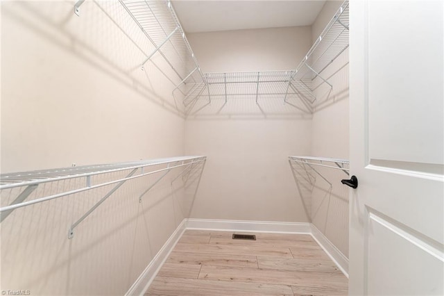 spacious closet featuring light wood-type flooring and visible vents