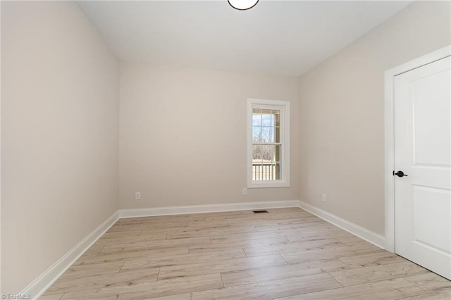 unfurnished room with light wood-style flooring and baseboards