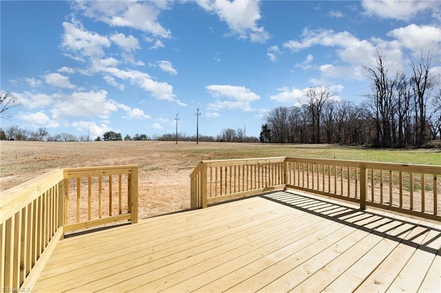 deck featuring a rural view and a lawn