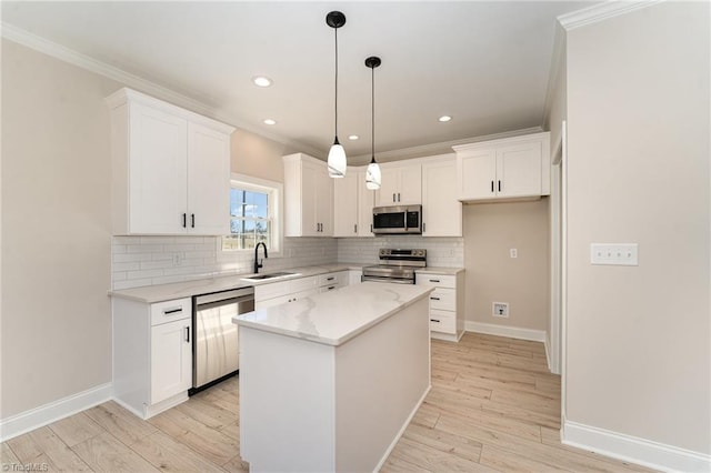 kitchen with ornamental molding, appliances with stainless steel finishes, light wood-style flooring, and tasteful backsplash