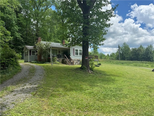 4679 S NC Highway 18, Moravian Falls, NC 28654 - view of front facade with gravel driveway, a front yard, a chimney, and a porch