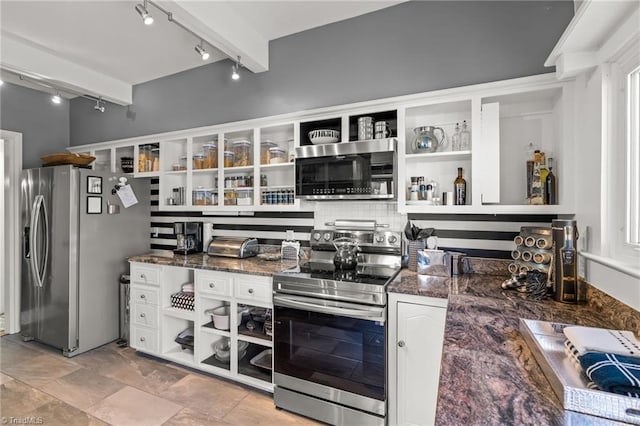 kitchen featuring white cabinets, appliances with stainless steel finishes, beamed ceiling, and dark stone counters