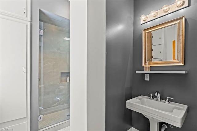 bathroom featuring sink and a shower with shower door