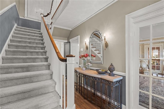 stairs with hardwood / wood-style floors and crown molding