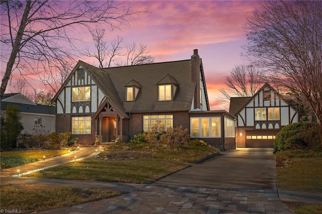 english style home featuring a garage